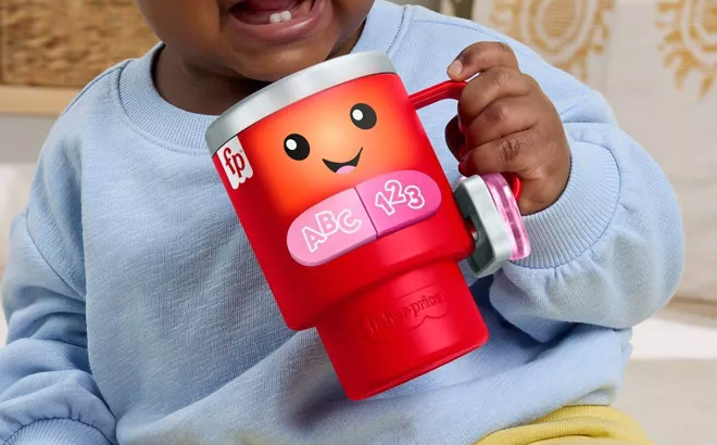 A Child Holding the Laugh Learn Red Coffee Cup