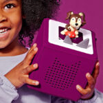 A Girl Holding Toniebox Audio Player Starter Set in Purple Color