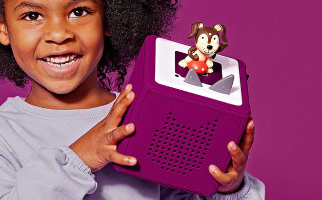 A Girl Holding Toniebox Audio Player Starter Set in Purple Color