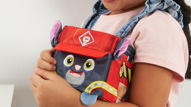 A Girl Holding the Rubble & Crew Charger 4-Inch Cube-Shaped Plush Toy