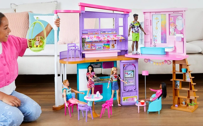 A Girl Playing with the Barbie Vacation House Dollhouse Playset