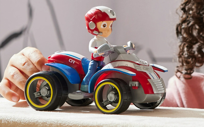 A Girl Playing with the Paw Patrol Ryder’s ATV Vehicle with Figure