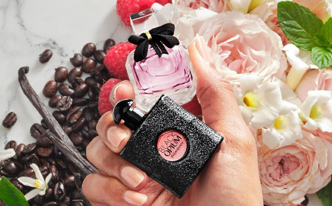 A Hand holding Yves Saint Laurent mini Mon Paris Eau de Parfum and Black Opium Eau de Parfum