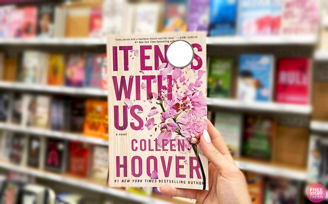 A Hand holding a It Ends with Us by Colleen Hoover Book