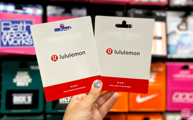 A Hand holding two Lululemon Gift Cards