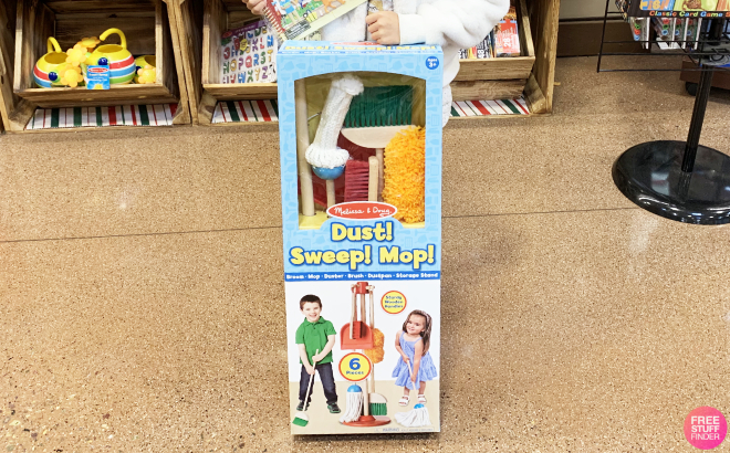 A Kid Holding a Melissa Doug Dust Sweep Mop 6 Piece Wood Cleaning Set