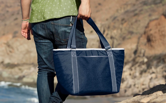 A Man Holding Picnic Time NCAA Topanga Tote Cooler Bag