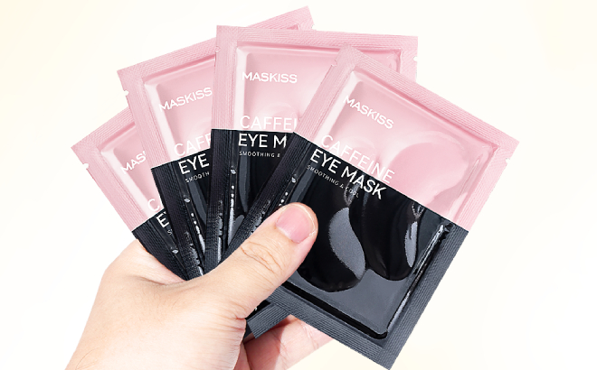 A PErson Holding Packs of Caffeine Eye Masks