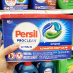 A Person Holding a Tub of Persil Pro Clean Discs