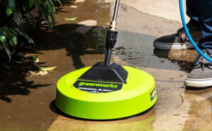 A Person Using a Greenworks Pressure Washer Surface Cleaner Attachment