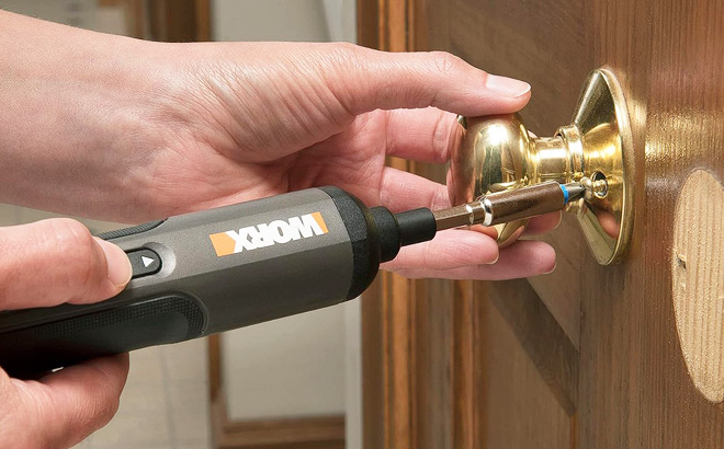 A Person Using a Worx Cordless Screwdriver to Tighten a Door Knob