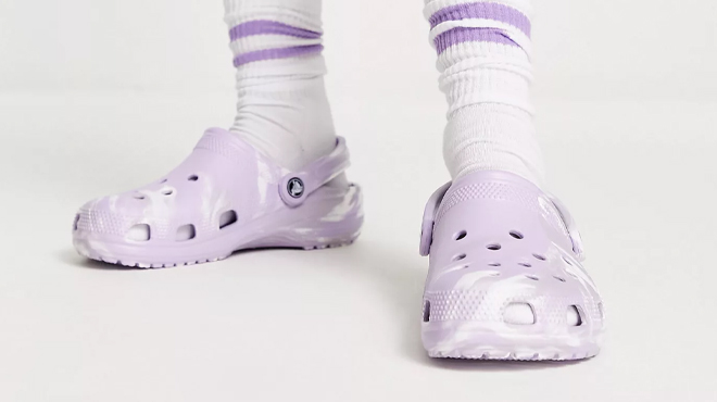 A Person Wearing Crocs Classic Marbled Clogs in Lavender White