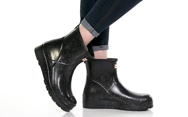 A Person Wearing Hunter Womens PLAY Starcloud Glitter Short Rain Boots