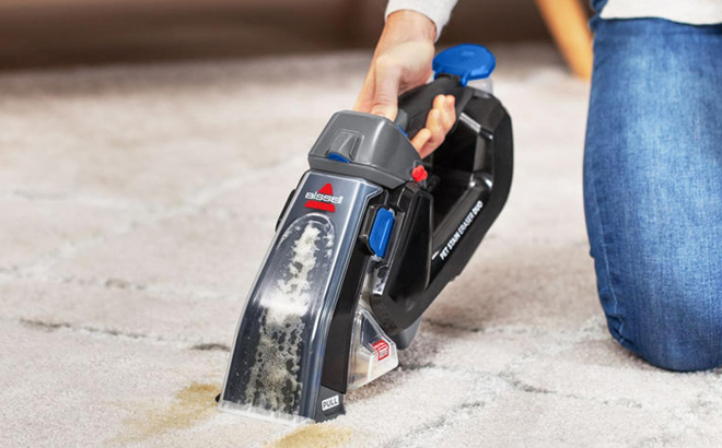 A Woman Cleaning Carpet Stains with the Bissell Pet Stain Eraser Plus Handheld Vacuum