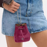 A Woman Holding Coach Outlet Drawstring Wristlet