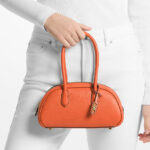 A Woman Holding Michael Kors Lulu Small Pebbled Leather Satchel in Optic Orange