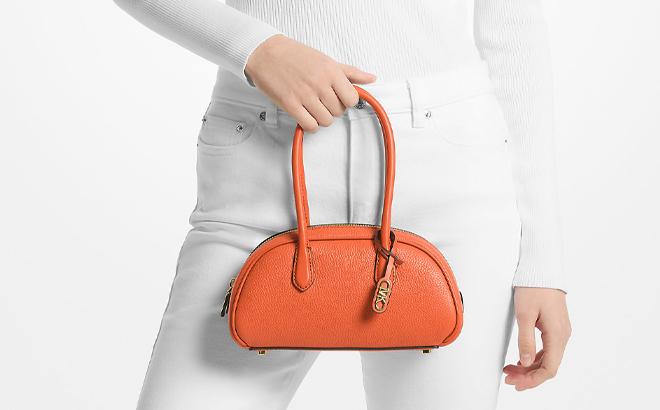 A Woman Holding Michael Kors Lulu Small Pebbled Leather Satchel in Optic Orange