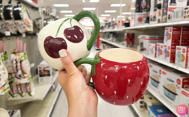 A Woman Holding Room Essentials Stoneware Cherries and Figural Strawberry Mugs