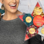 A Woman Holding Scunci by Conair 5 Piece Christmas Scrunchie Star Gift Box