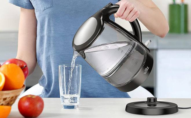 A Woman Pouring Water from the Willz Electric Glass Kettle