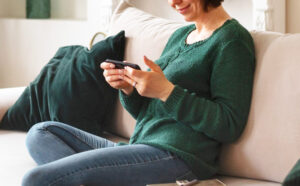 A Woman Sitting on a Couch and Using a Phone to Earn Some Extra Cash in Free Time