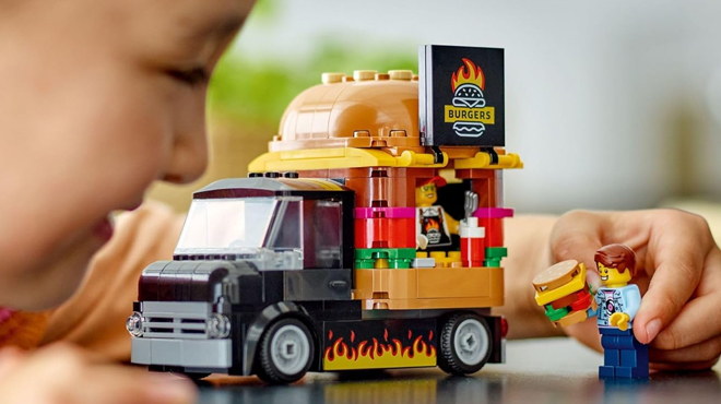 A child playing with LEGO City Burger Truck Toy Building Set