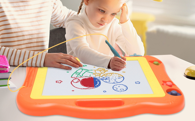 A girl drawing an object with a Bablocvid Magnetic Drawing Board