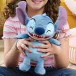 A girl holding a Disney Crack Me Up Snitch 11 inch Plush