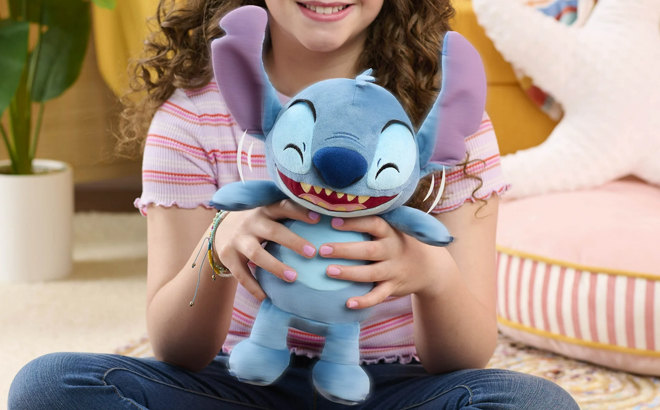 A girl holding a Disney Crack Me Up Snitch 11 inch Plush