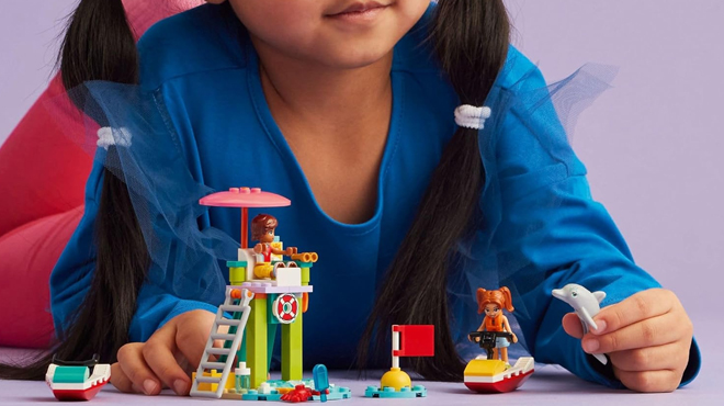 A girl playing with LEGO Friends Beach Water Scooter