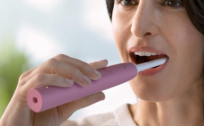 A person brushing her teeth using Philips Sonicare 4100 Power Toothbrush