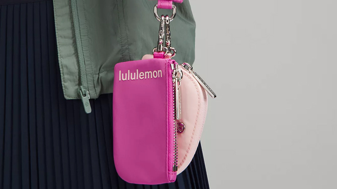 A person caryying a Lululemon Dual Pouch Wristlet