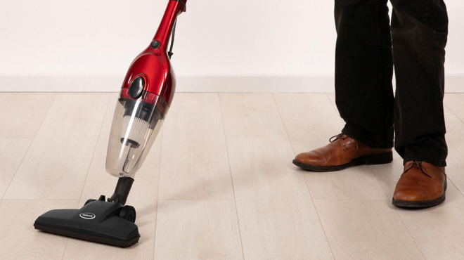 A person cleaning the floor using Ewbank Stick Vacuum