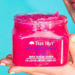 A person holding a Tree Hut Raspberry Fizz Shea Sugar Scrub