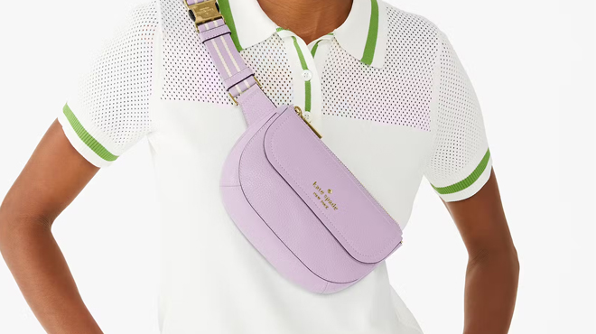 A person slinging a Violet Mist Kate Spade Rosie Belt Bag