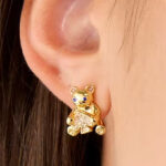 A person wearing Kate Spade Teddy Bear Studs