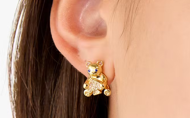 A person wearing Kate Spade Teddy Bear Studs