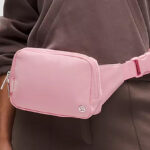 A person wearing a pink Lululemon Everywhere Belt Bag Large 2L