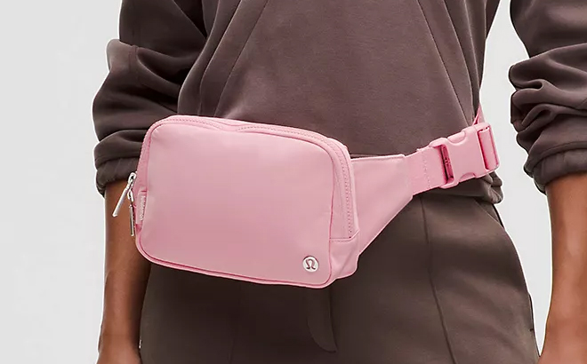 A person wearing a pink Lululemon Everywhere Belt Bag Large 2L