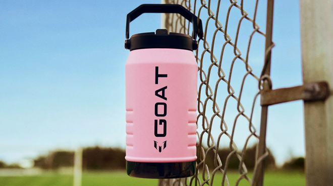 The Messi x Stanley IceFlow Flip Straw Jug Hanging from a Fence