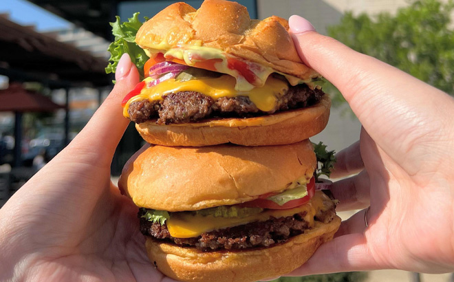 a Person Holding Two Smashburgers