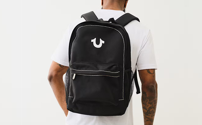 A Man Wearing True Religion Horseshoe Logo Backpack