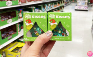 A Person Holding Two Hersheys Grinch Christmas Candy Gift Box