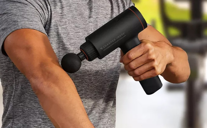 A Person Using the Sharper Image Powerboost Sport Percussion Handheld Massager