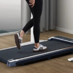 A Person Walking on the Walking Pad Under Desk Treadmill with Remote Control