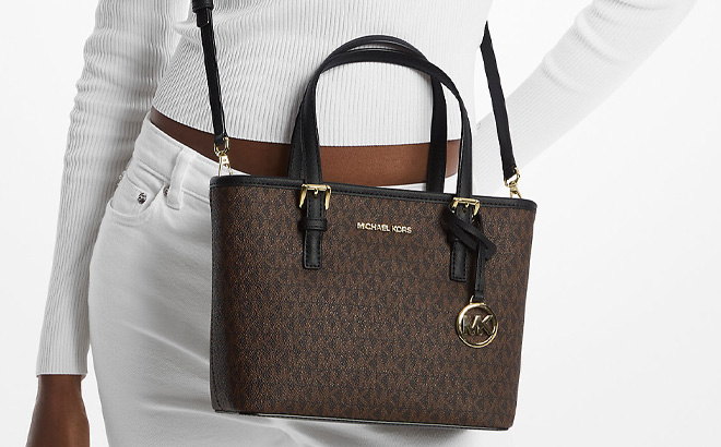 A Person Wearing Michael Kors Jet Set Travel Extra Small Logo Top Zip Tote Bag