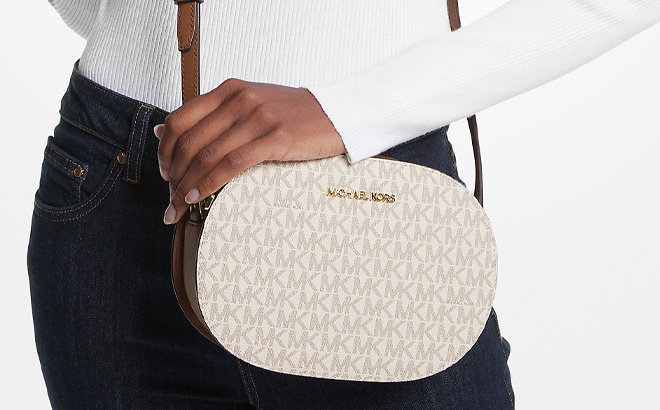 A Person Wearing Michael Kors Jet Set Travel Medium Signature Logo Crossbody Bag in Vanilla Color