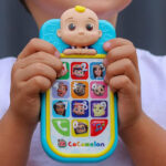 A Person holding a CoComelon JJs First Learning Toy Phone