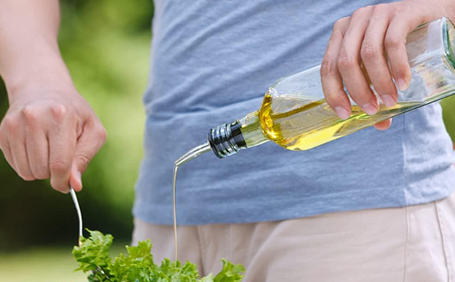 A Person holding a Leaflai Oil Dispenser Bottle