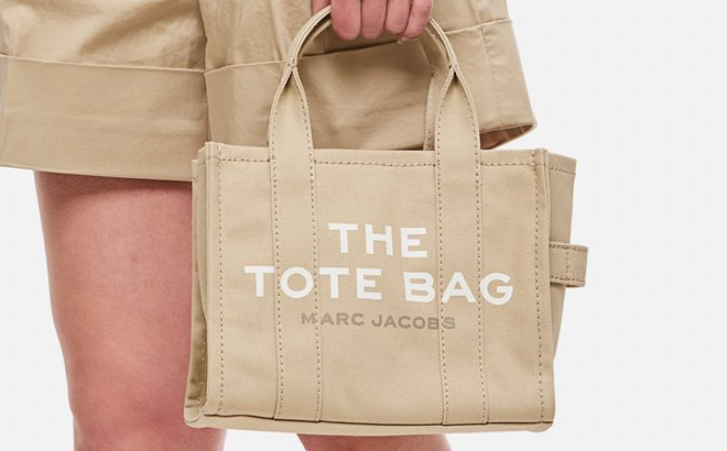 A Woman Holding Marc Jacobs The Small Tote Bag in Beige